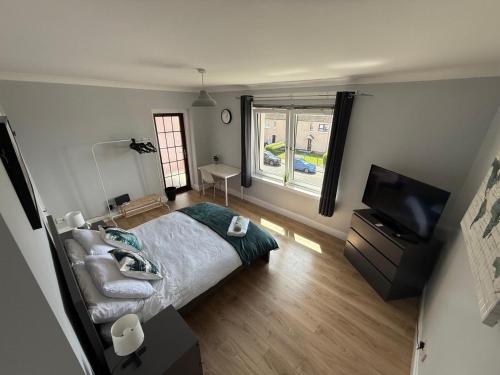a bedroom with a bed and a flat screen tv at Musselburgh Apartment with 3 Bedrooms in Musselburgh