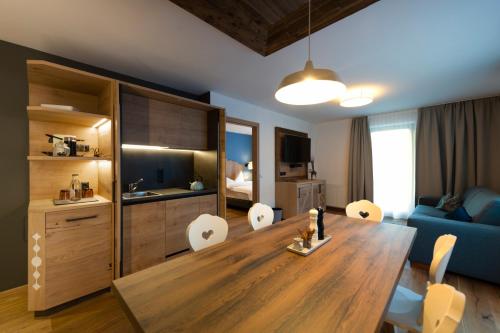 a living room with a table and a blue couch at Sepp & Hannis Suiten im Dorf in Neustift im Stubaital