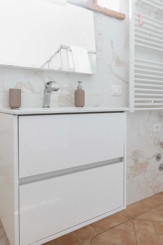 a white bathroom with a sink and a mirror at Agriturismo Le Cerrete in Chiusi
