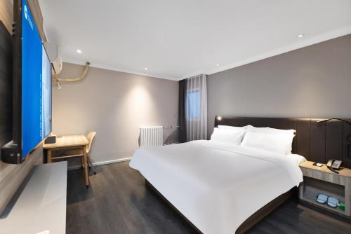 北京Hanting Hotel Beijing West Railway Station South Square的配有一张大床和一张书桌的酒店房间