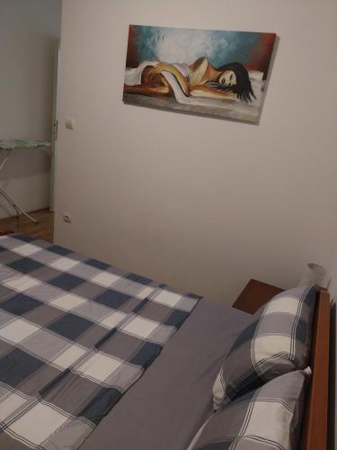 a bedroom with a bed with a painting on the wall at Apartman Elena Budva in Budva