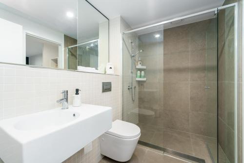 a bathroom with a toilet and a sink and a shower at Luxury 1BR Apt with Lake Views in Belconnen - Hosted by Canstay in Belconnen