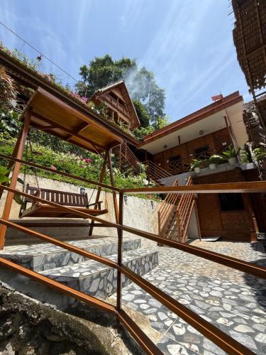 a staircase leading up to a house with a bench at Camiguin Blue Lagoon Cottages in Mahinog