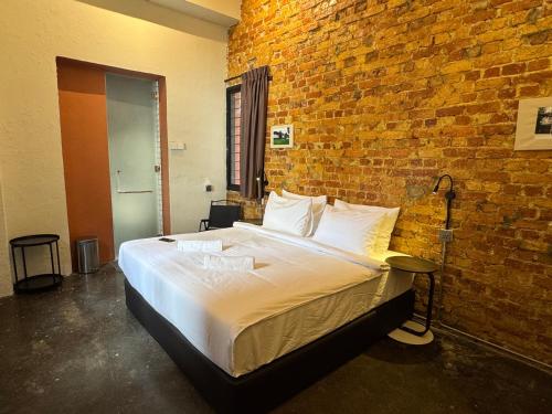 a bedroom with a large bed in a brick wall at Miner's House Ipoh in Ipoh