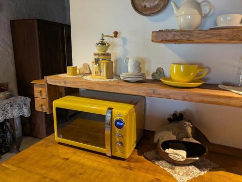 a yellow microwave sitting on top of a table at Chaloupka u Mostu sv Jana v centru Vodňan in Vodňany