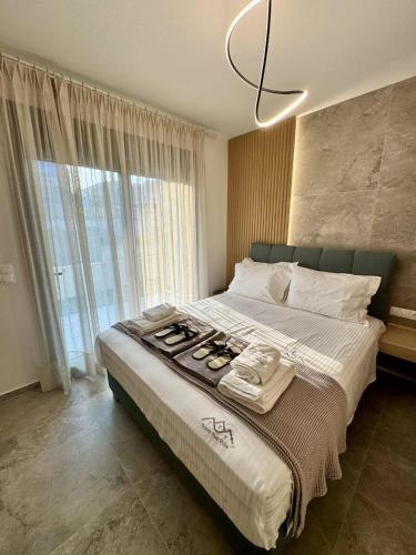 a bedroom with a large bed with a large window at Trinity Pool Villas GOLD in Iraklitsa