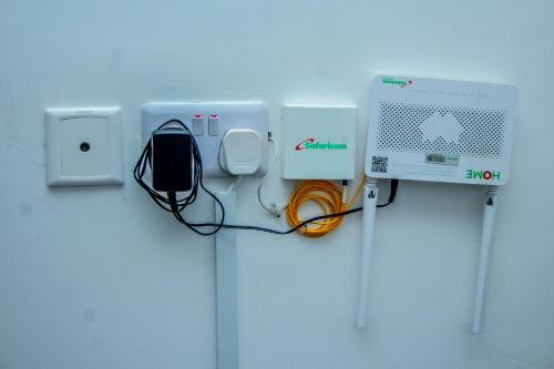 a room with a wall with a computer and a monitor and cables at Essence Urban Homes STUDIO in Kisumu