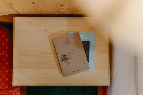 a wooden table with a card and a book on it at Kinderhotel Stegerhof in Donnersbachwald