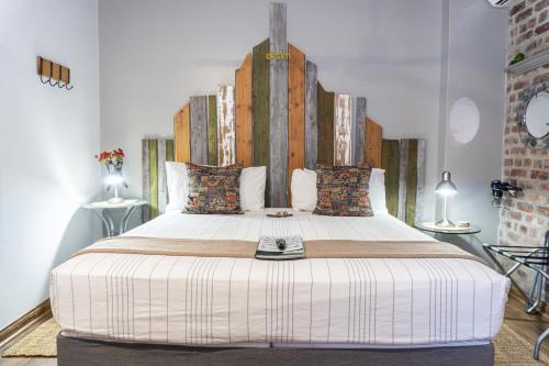a bedroom with a large bed with a wooden headboard at Earthbound Guest House in Oudtshoorn