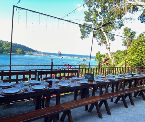 a long wooden table with plates and dishes on it at Camiguin Blue Lagoon Cottages in Mahinog