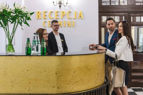 a group of people standing around a yellow counter at Dom Zdrojowy CECHINI in Żegiestów