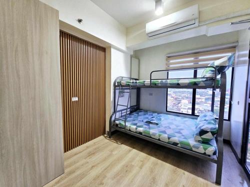 a bunk bed in a room with a window at Mabolo Garden Flats Loft by Cebu Getaway in Sampong