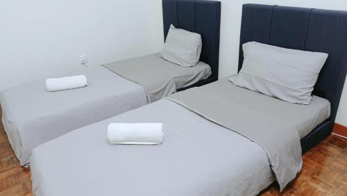 two beds in a room with white sheets and pillows at Heart Bentong Guest House 文冬心宿民宿 Bentong Homestay in Bentong
