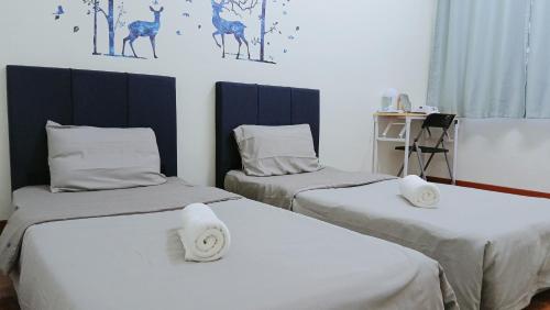 a room with two beds with white sheets at Heart Bentong Guest House 文冬心宿民宿 Bentong Homestay in Bentong