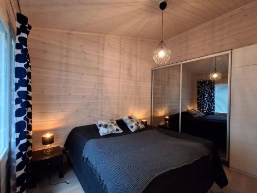 Un dormitorio con una cama y un espejo grande. en Kekäle, en Syöte