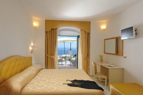 a bedroom with a bed and a view of the ocean at Hotel Villa Maria Pia in Praiano