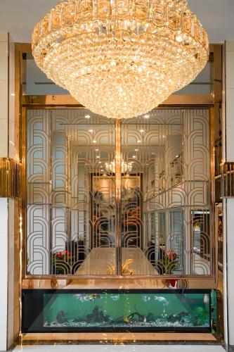 a large chandelier hangs over a window in a store at Golden Empire Suvarnabhumi Hotel in Bang Kew Yai