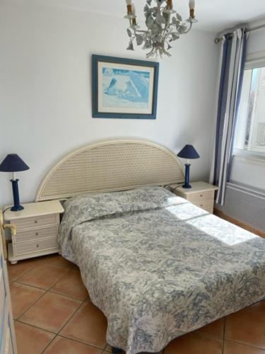 a bedroom with a large bed and two night stands at Résidence C2M Appartement sur plage Grau du Roi in Le Grau-du-Roi