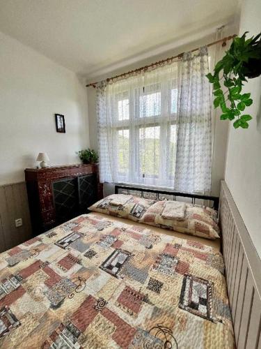 a bedroom with a large bed with a quilt on it at Ubytování Na Kovárně in Smržovka