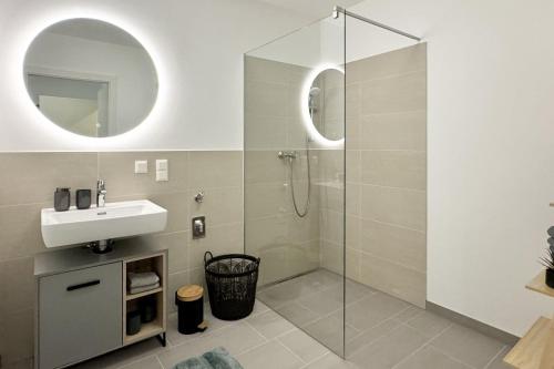 un bagno con doccia, lavandino e specchio di Modernes Studio im Dachgeschoß a Wiener Neustadt