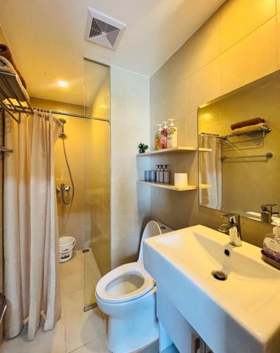 Un baño con un inodoro blanco y un lavabo. en Modern-esque Room at Megaworld, en Iloilo City