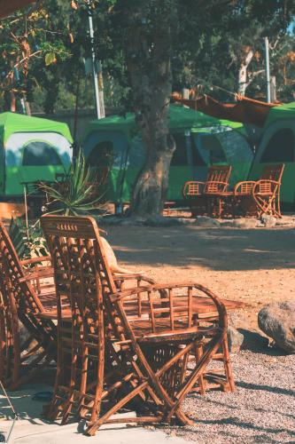 a group of wooden benches sitting in a park at Mosh Achziv Beach in Gesher HaZiw
