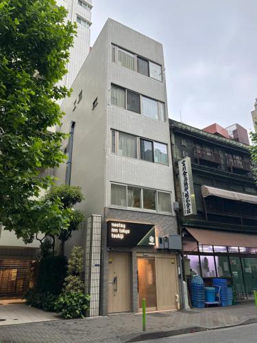 a tall building with a sign on the side of it at nestay inn tokyo tsukiji in Tokyo