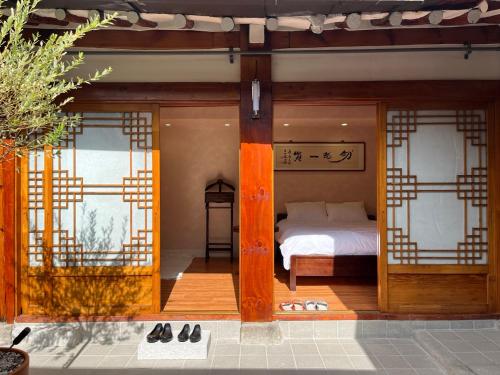 ein Schlafzimmer mit einem Bett und zwei Fenstern in der Unterkunft Seoul Bukchon Homi Hanok in Seoul