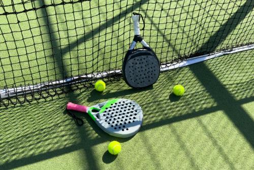 a tennis racket and tennis balls on a net at Moorea Boutique Resort Samui in Ban Tai