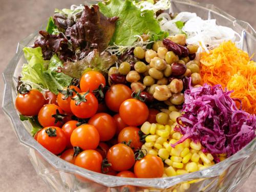 a bowl filled with tomatoes lettuce and other vegetables at Nishitetsu Inn Kochi Harimayabashi in Kochi