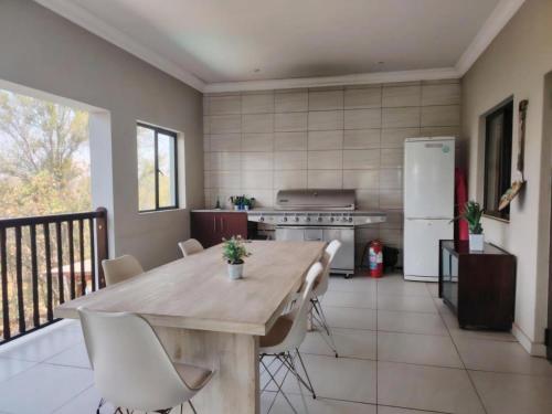 a large kitchen with a wooden table and chairs at Bokmakierie Place in Modimolle