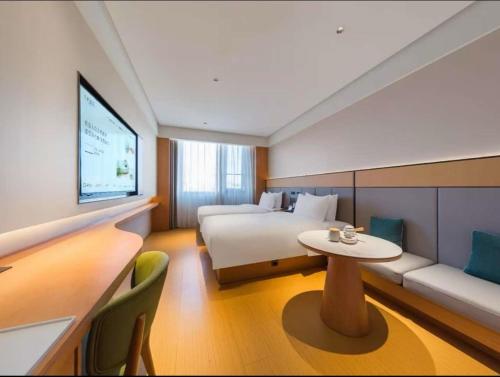 a hotel room with a bed and a table and a couch at JI Hotel Beijing Huilongguan West Street全季北京回龙观西大街酒店 in Beijing