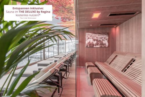 a row of benches in a building with a plant at Sporthotel Bergheim in Sölden