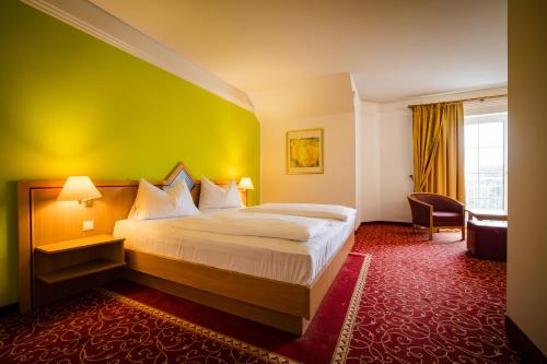 a hotel room with a bed with a green wall at Thermenhotel Vier Jahreszeiten in Lutzmannsburg