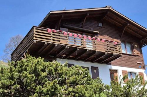 a house with a balcony with pink flags on it at Revier mon désir in Braunwald