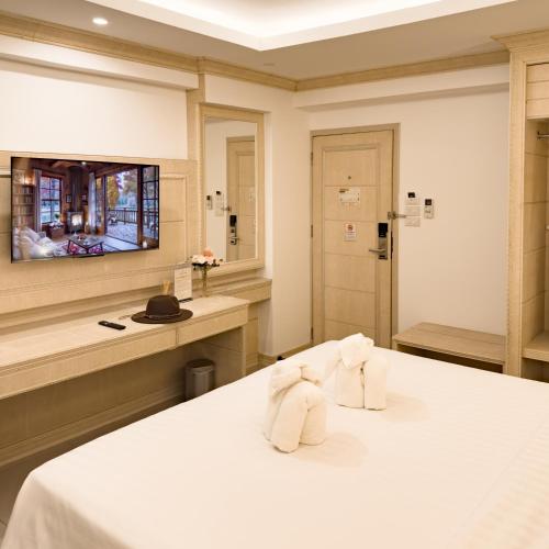 a hotel room with a bed and a television at Golden Empire Suvarnabhumi Hotel in Bang Kew Yai