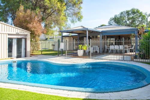 a swimming pool in a yard next to a house at Happy Daze Beach House-Pool in Broadwater