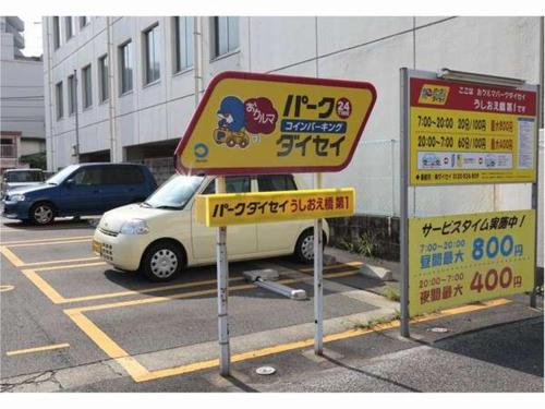 a sign in a parking lot next to a car at Nishitetsu Inn Kochi Harimayabashi in Kochi