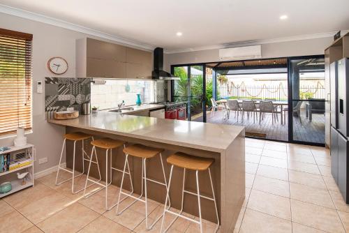 a kitchen with a large counter with stools at Happy Daze Beach House-Pool in Broadwater