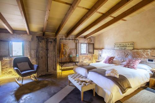 a large bedroom with two beds and a chair at Agroturismo Petit Hotel Son Perdiu - Adults Only in Sa Ràpita