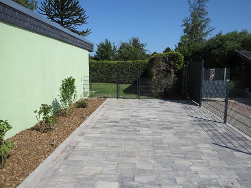 a driveway with a fence in a yard at Nordseeferienhaus Emma Tossens in Butjadingen