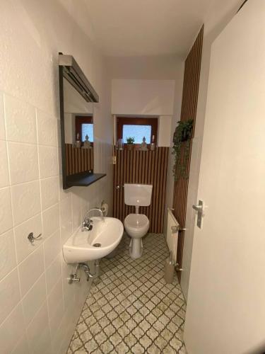 a bathroom with a white toilet and a sink at Ferienhaus Burgblick in Hürtgenwald