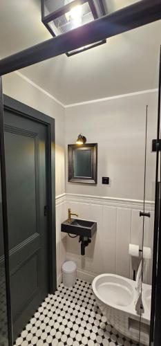 a bathroom with a sink and a toilet and a tub at Apartament przy Poczcie in Koszalin
