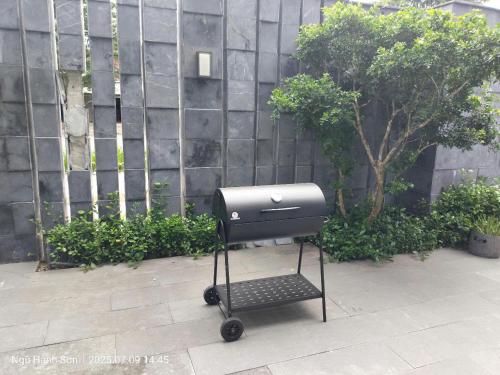 a grill on a cart in front of a wall at Willowvilla - Oneriver Villa in Kon Rung (1)