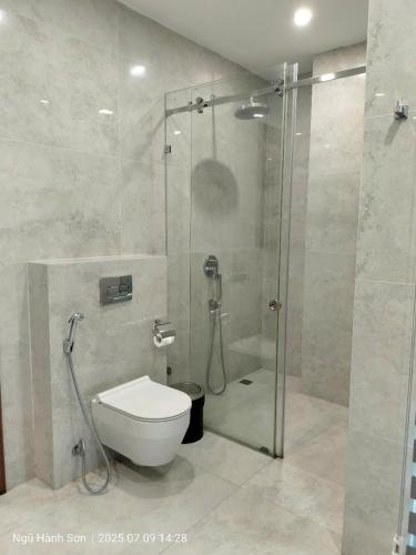a bathroom with a toilet and a glass shower at Willowvilla - Oneriver Villa in Kon Rung (1)