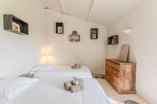 a bedroom with two beds and a wooden dresser at La Marais - Parking - Jardin in Bouin