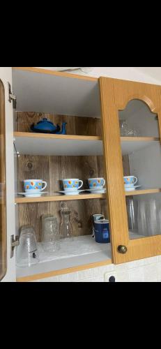 a cabinet with bowls and dishes in it at Mimi's House 1 in Chios