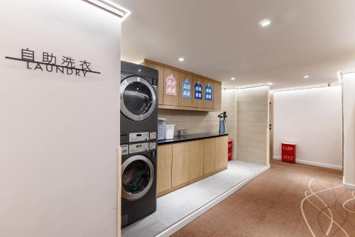 北京Hanting Hotel Beijing West Railway Station South Square的配有洗衣机和烘干机的洗衣房