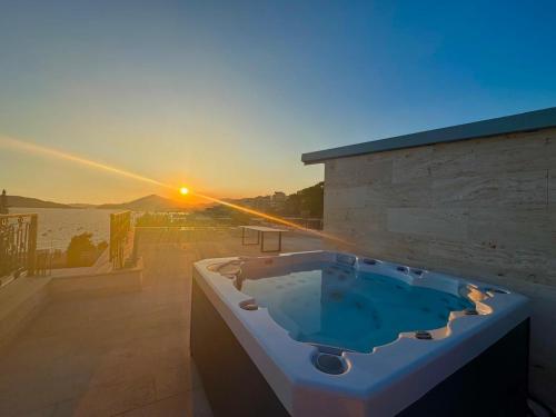 a jacuzzi tub with the sunset in the background at Luxury Apartments Przno in Budva