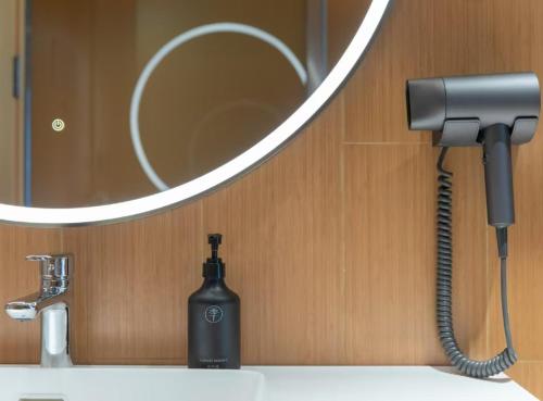 a blow dryer on a bathroom sink in front of a mirror at JI Hotel Beijing Huilongguan West Street全季北京回龙观西大街酒店 in Beijing